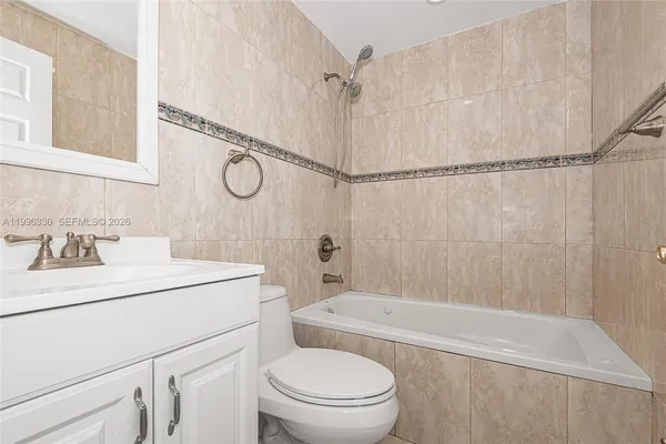 a bathroom with a toilet sink vanity tub and shower
