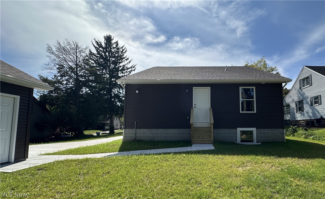 363 Sexton Street Struthers, OH 44471 - Photo 2 of 20 Dark brown vinyl siding with white trim, and a white paneled exterior door