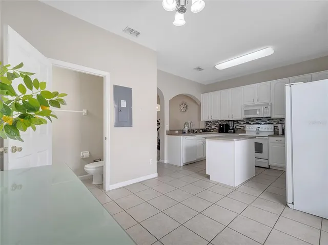 a kitchen with white cabinets and appliances