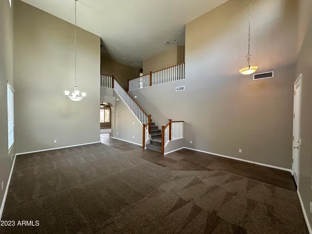 a view of an empty room with stairs and a window