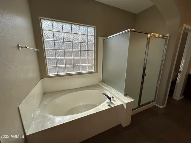 a large bathroom with a double vanity sink and mirror with bathtub