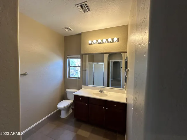 a bathroom with a toilet a sink and mirror