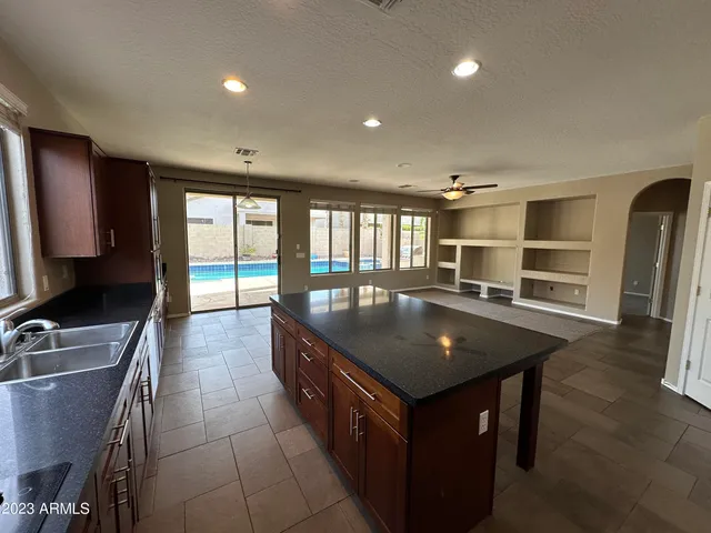 a kitchen with stainless steel appliances granite countertop a sink a stove and a refrigerator