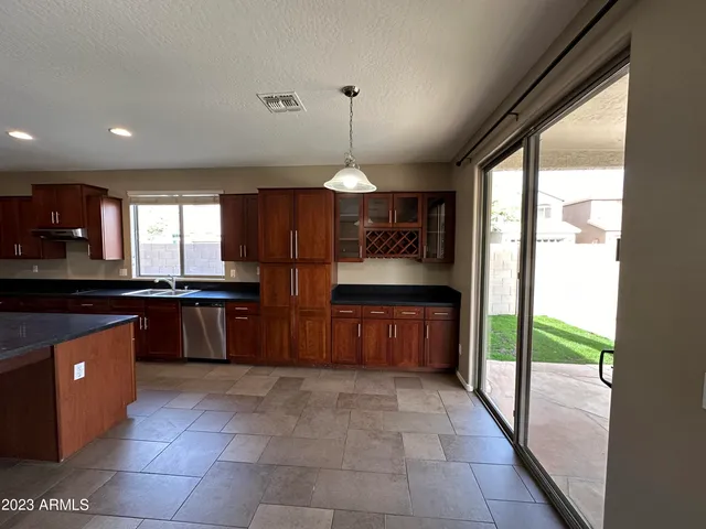 a kitchen with kitchen island granite countertop a stove a sink and a refrigerator