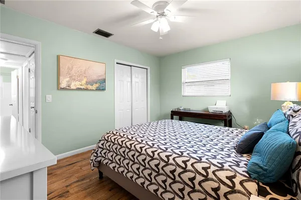 a bedroom with a bed and wooden floor