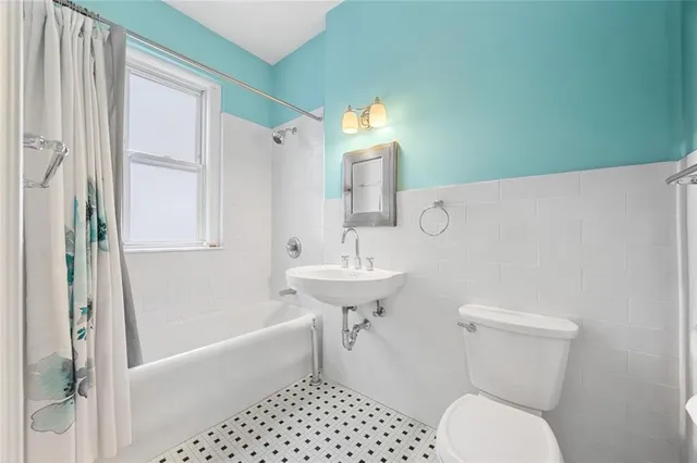 a bedroom with a bed a dresser and a large window