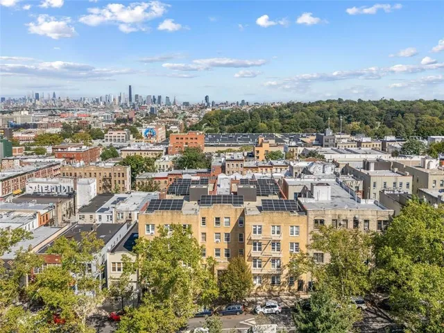 an aerial view of residential houses with outdoor space and ocean view