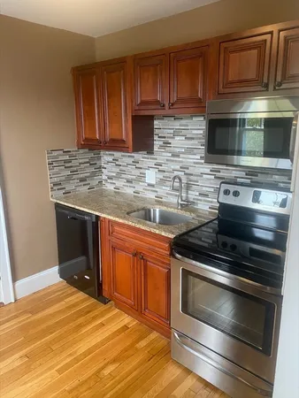 a kitchen with stainless steel appliances granite countertop a stove microwave and cabinets