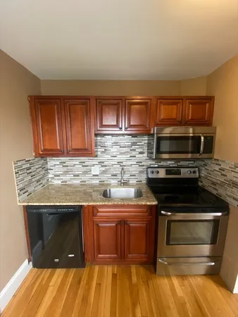 a kitchen with granite countertop a stove and a sink