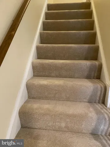 a living room with furniture and stairs