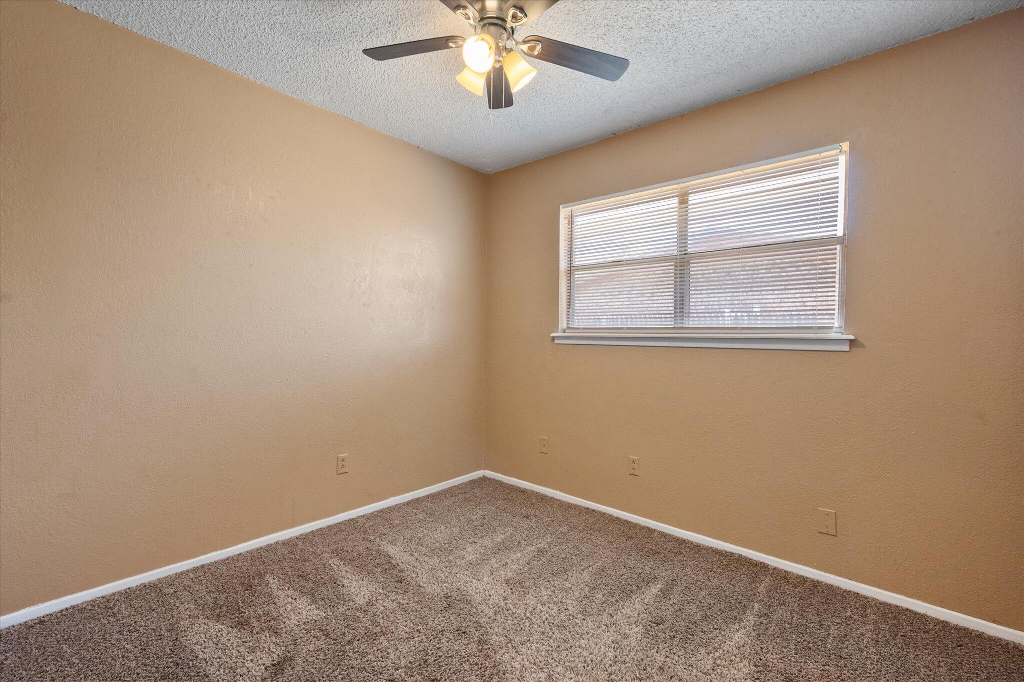 6407 28th Street Lubbock, TX 79407 - Photo 17 of 23 an empty room with windows and fan