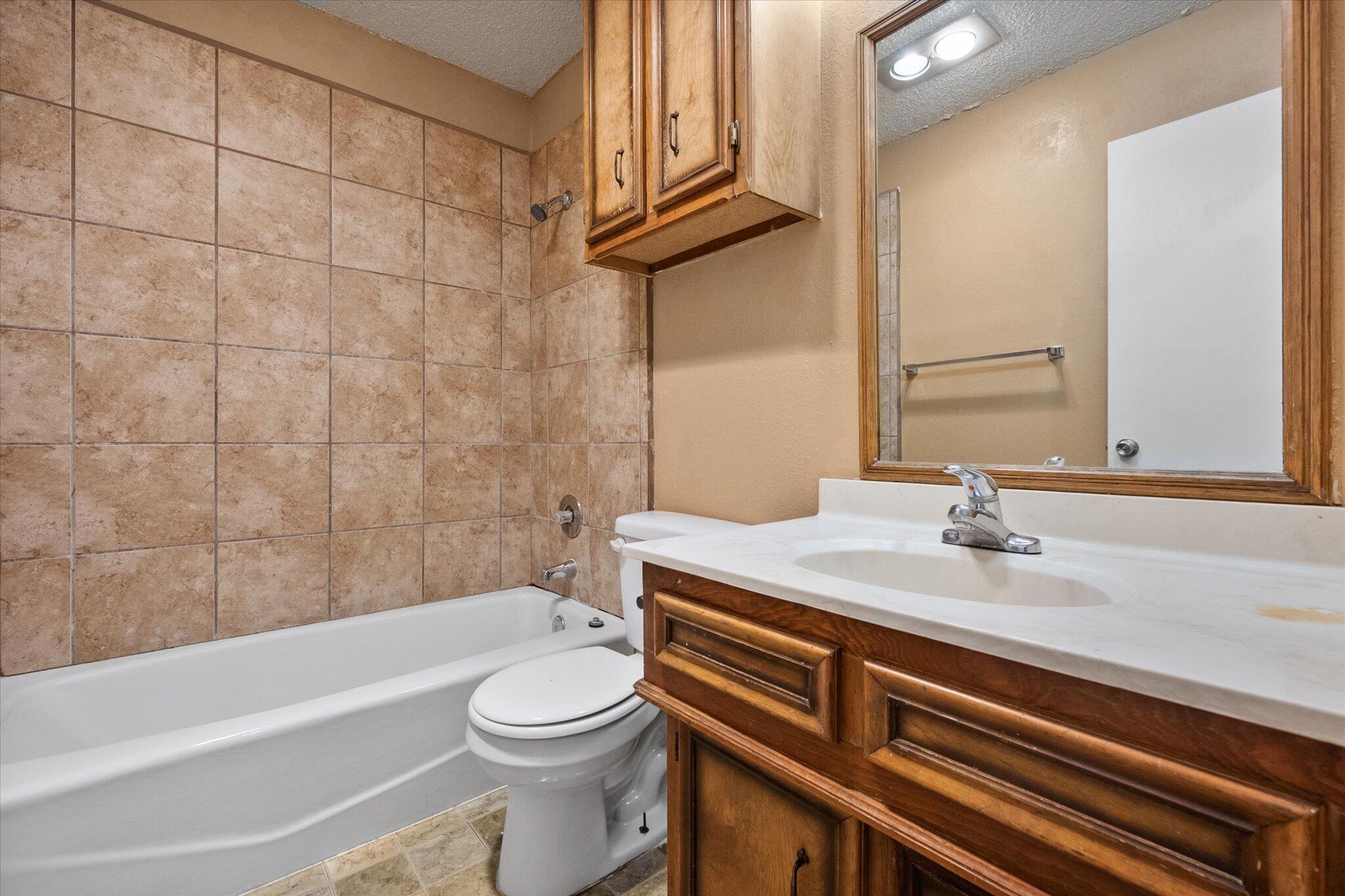 6407 28th Street Lubbock, TX 79407 - Photo 18 of 23 a bathroom with a sink a toilet and bathtub