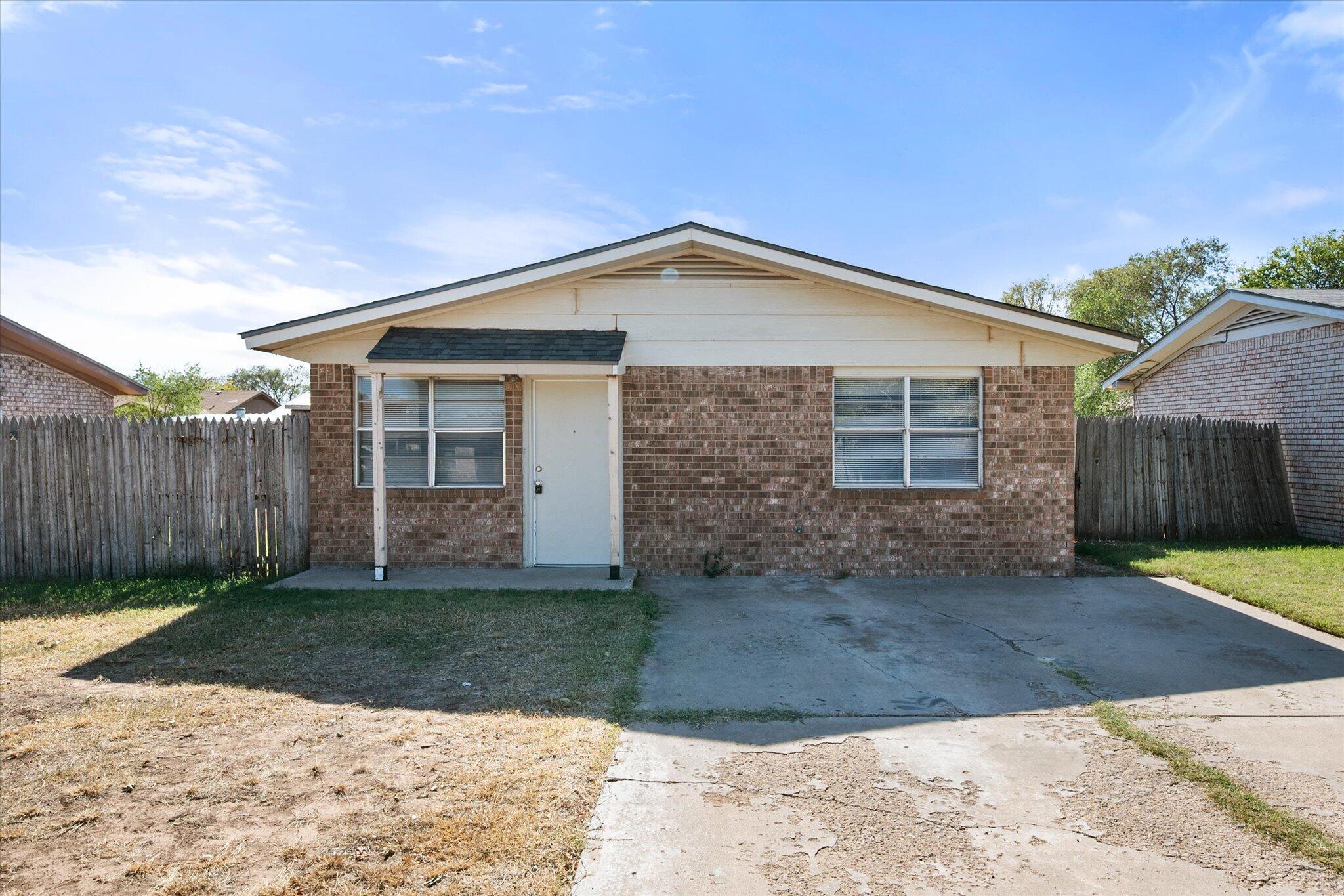 6407 28th Street Lubbock, TX 79407 - Photo 2 of 23 a front view of a house with a yard