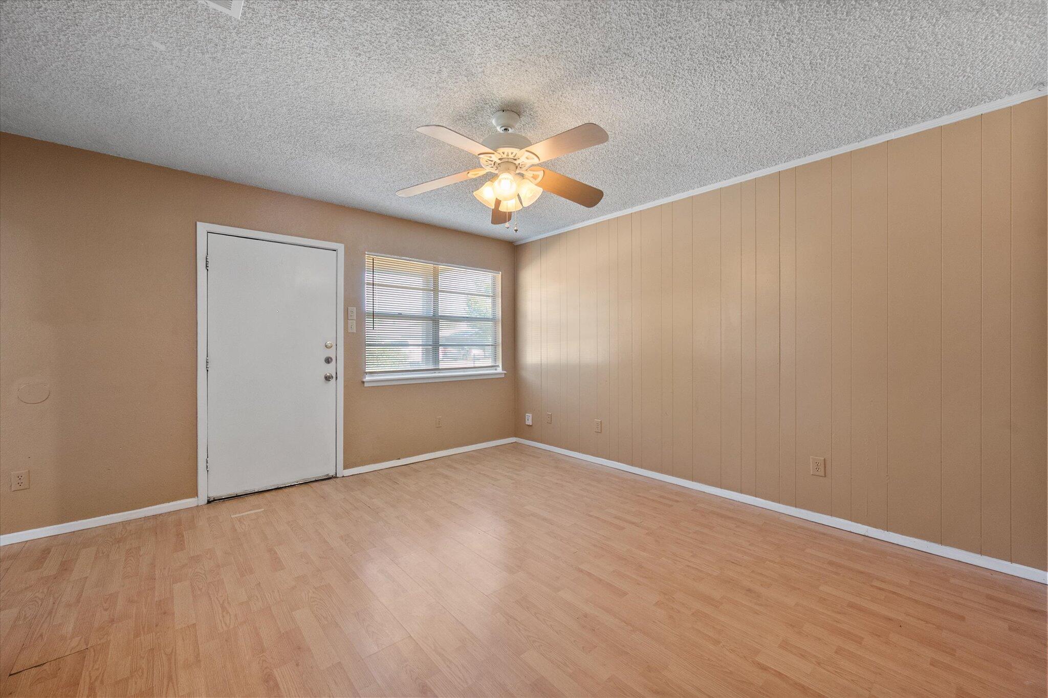 6407 28th Street Lubbock, TX 79407 - Photo 7 of 23 an empty room with a window and a ceiling fan