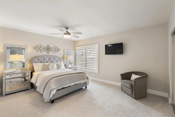 a spacious bedroom with a bed and a television