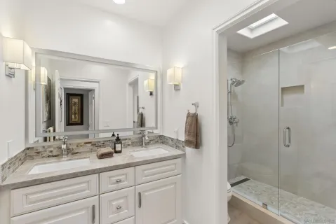 a bathroom with a shower tub double vanity sink and mirror