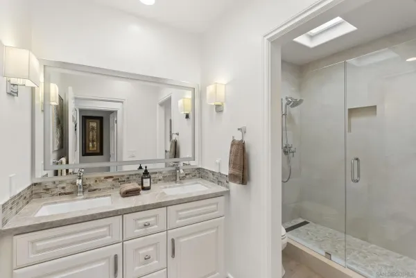 a bathroom with a shower tub double vanity sink and mirror