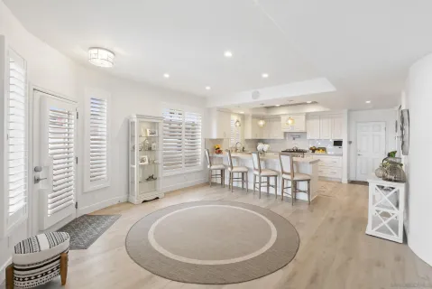 a living room with furniture a table and kitchen view