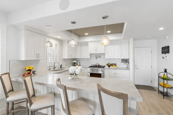 a kitchen with refrigerator and chairs
