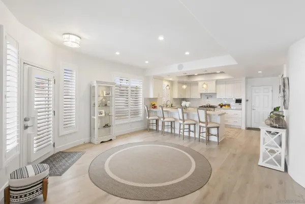 a living room with furniture a table and kitchen view