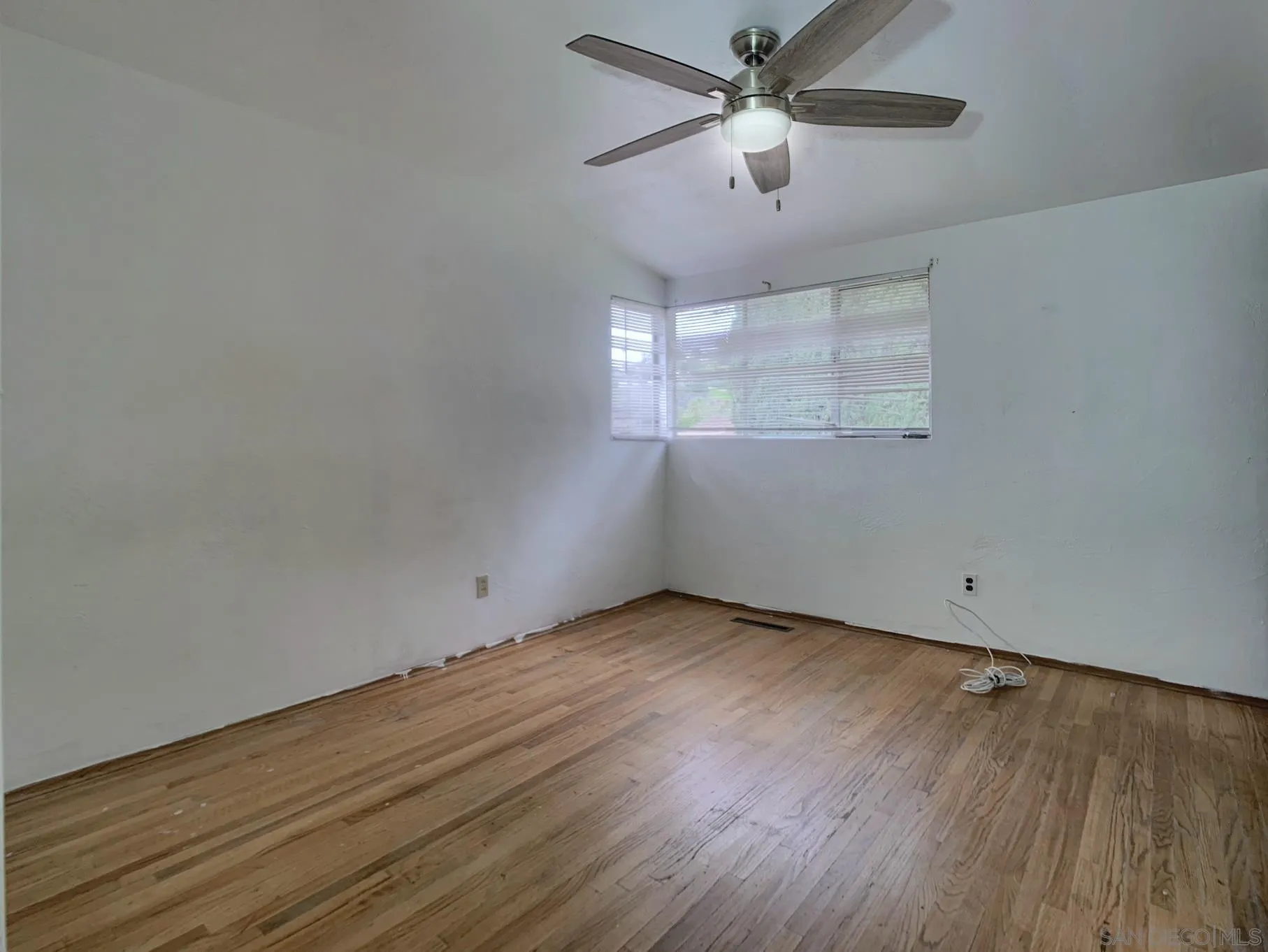 4240 Camino Paz La Mesa, CA 91941 - Photo 16 of 33 an empty room with wooden floor ceiling fan and windows
