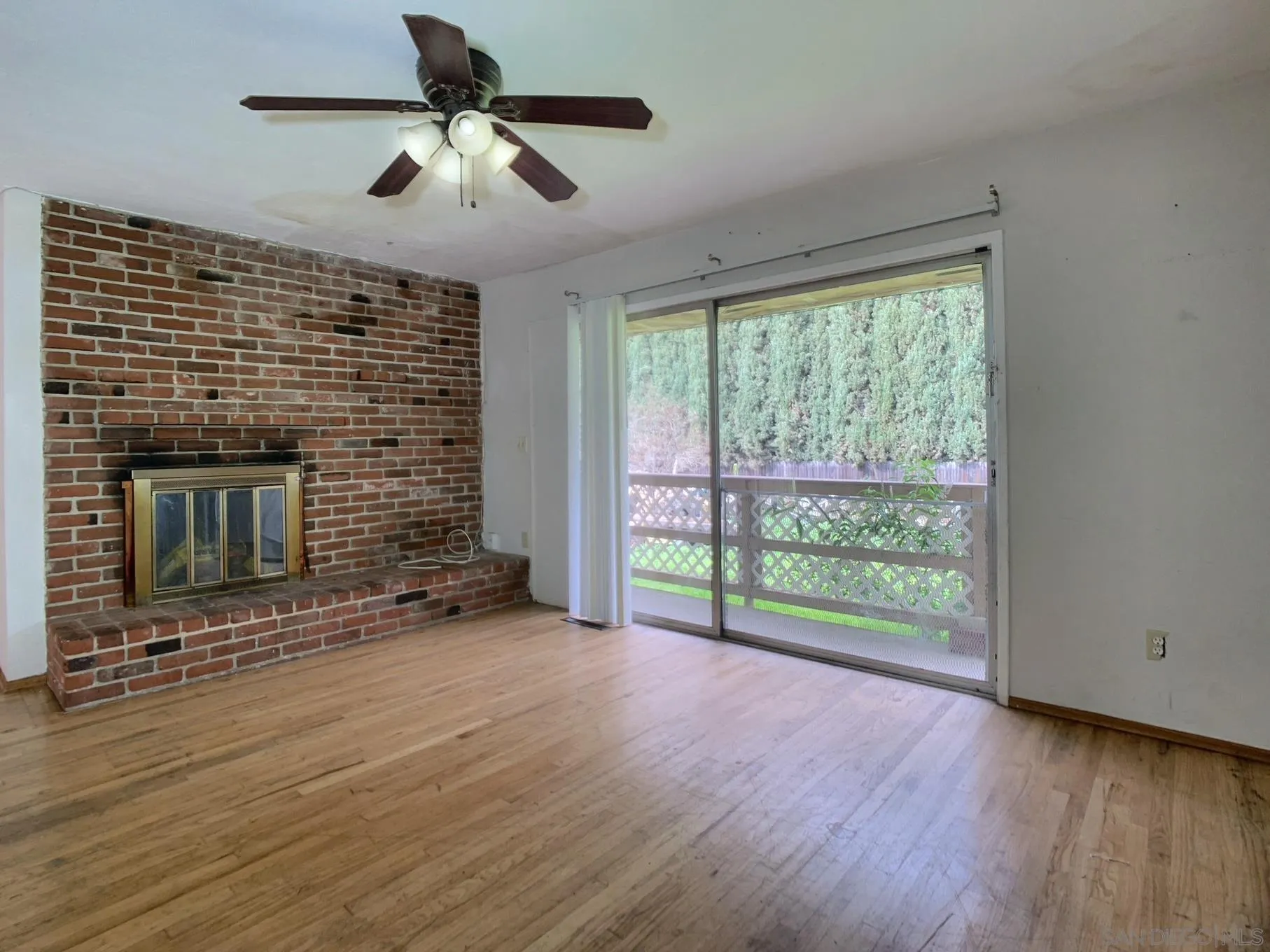 4240 Camino Paz La Mesa, CA 91941 - Photo 5 of 33 a view of an empty room with wooden floor fireplace and a window