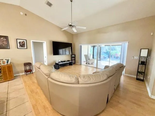 a living room with patio furniture and a flat screen tv