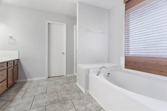 a spacious bathroom with a bathtub and shower