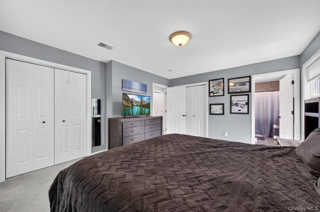 a bedroom with a large bed and a flat tv screen