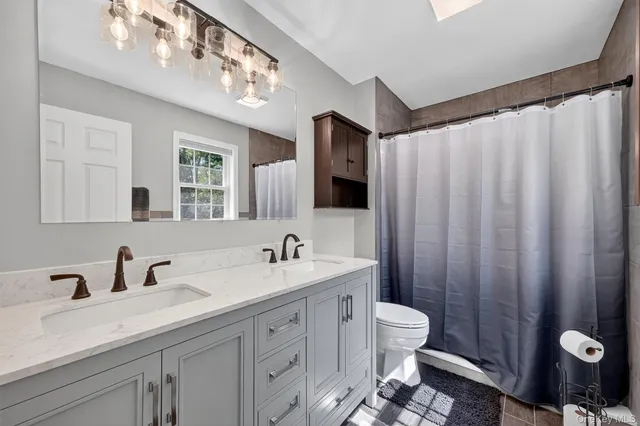 a bedroom with a bed and a dresser with mirror