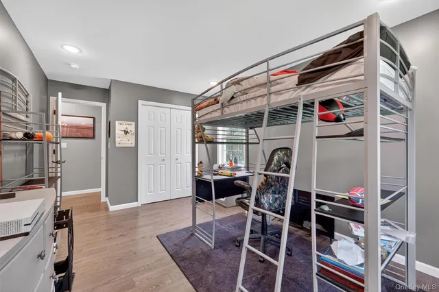 a bedroom with a bed and a wooden floor