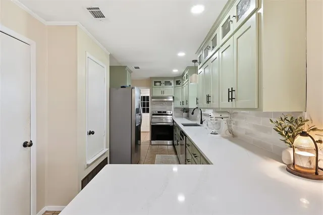 a kitchen with a sink and a stove top oven with wooden floor
