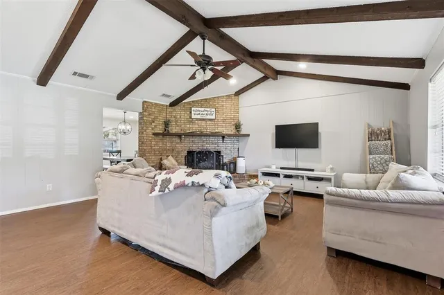 a living room with furniture a fireplace and a flat screen tv