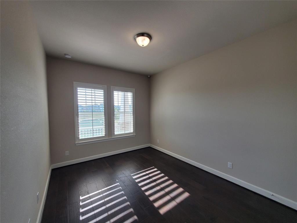 2846 Lotus Street Carrollton, TX 75007 - Photo 13 of 21 an empty room with wooden floor and windows