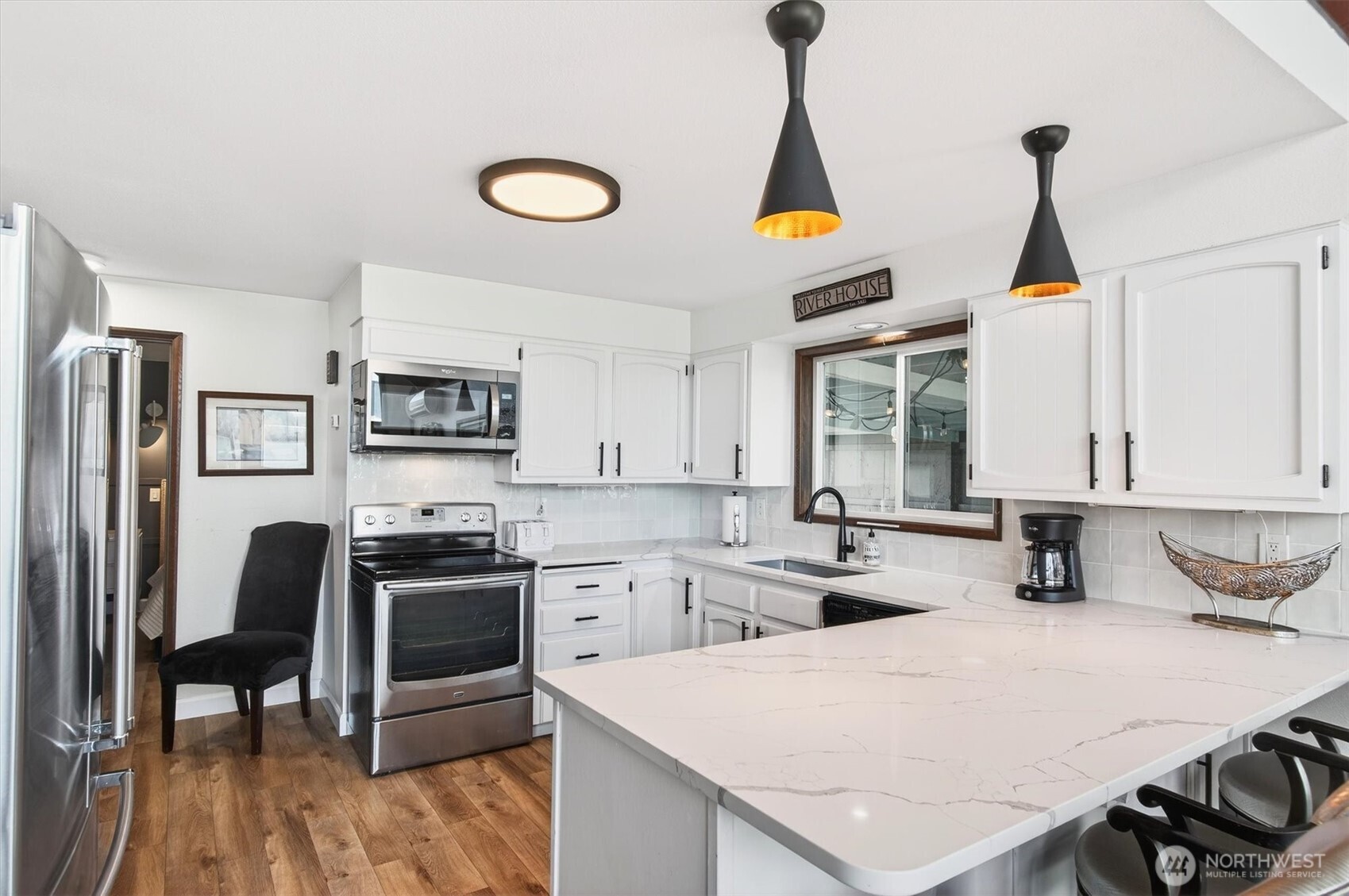 301 West Sunny Sands Road Cathlamet, WA 98612 - Photo 23 of 39 a kitchen with stainless steel appliances a stove a refrigerator a sink a stove and white cabinets with wooden floor