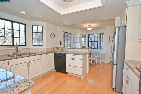 a kitchen with granite countertop white cabinets and stainless steel appliances