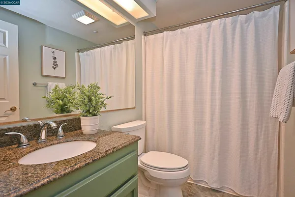 a hallway with white cabinets and chandelier