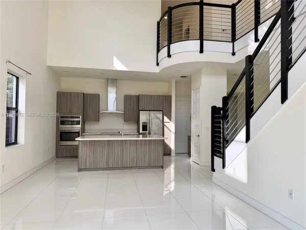a view of kitchen with stainless steel appliances cabinets and staircase