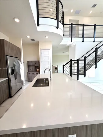 a kitchen with stainless steel appliances a white refrigerator a sink a stove and oven