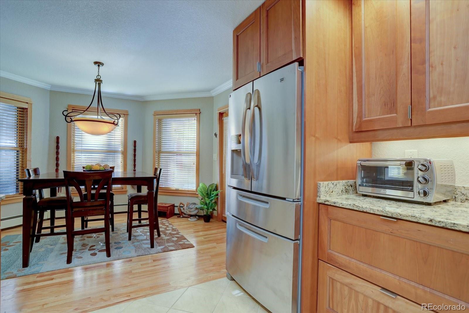 815 16th Street Boulder, CO 80302 - Photo 11 of 47 a kitchen with stainless steel appliances granite countertop a refrigerator a stove a dining table and chairs