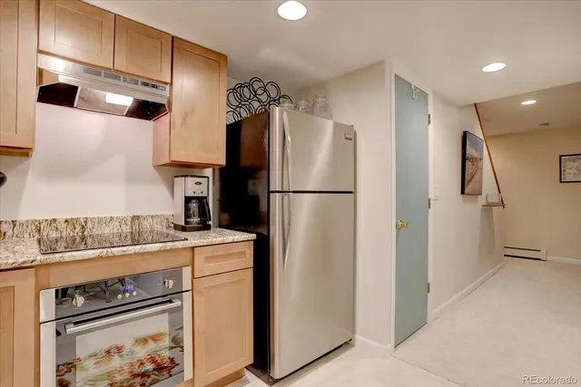a kitchen with a refrigerator and a stove top oven