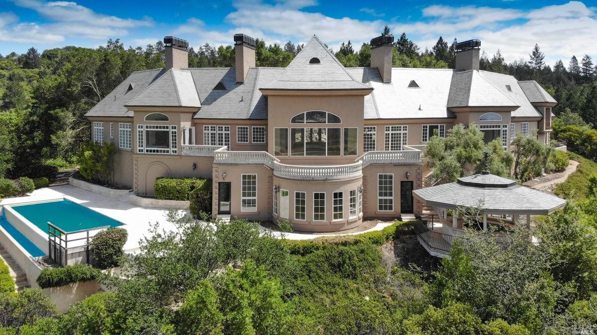 an aerial view of a house with swimming pool garden and patio