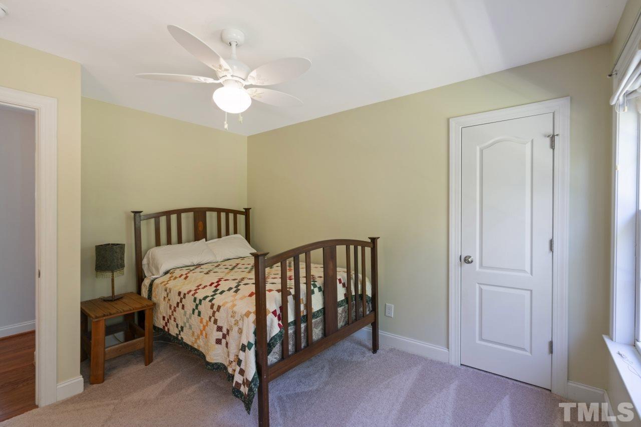 135 Cattle Farm Drive Raleigh, NC 27603 - Photo 21 of 30 a bed sitting in a bedroom next to a window and a chandelier