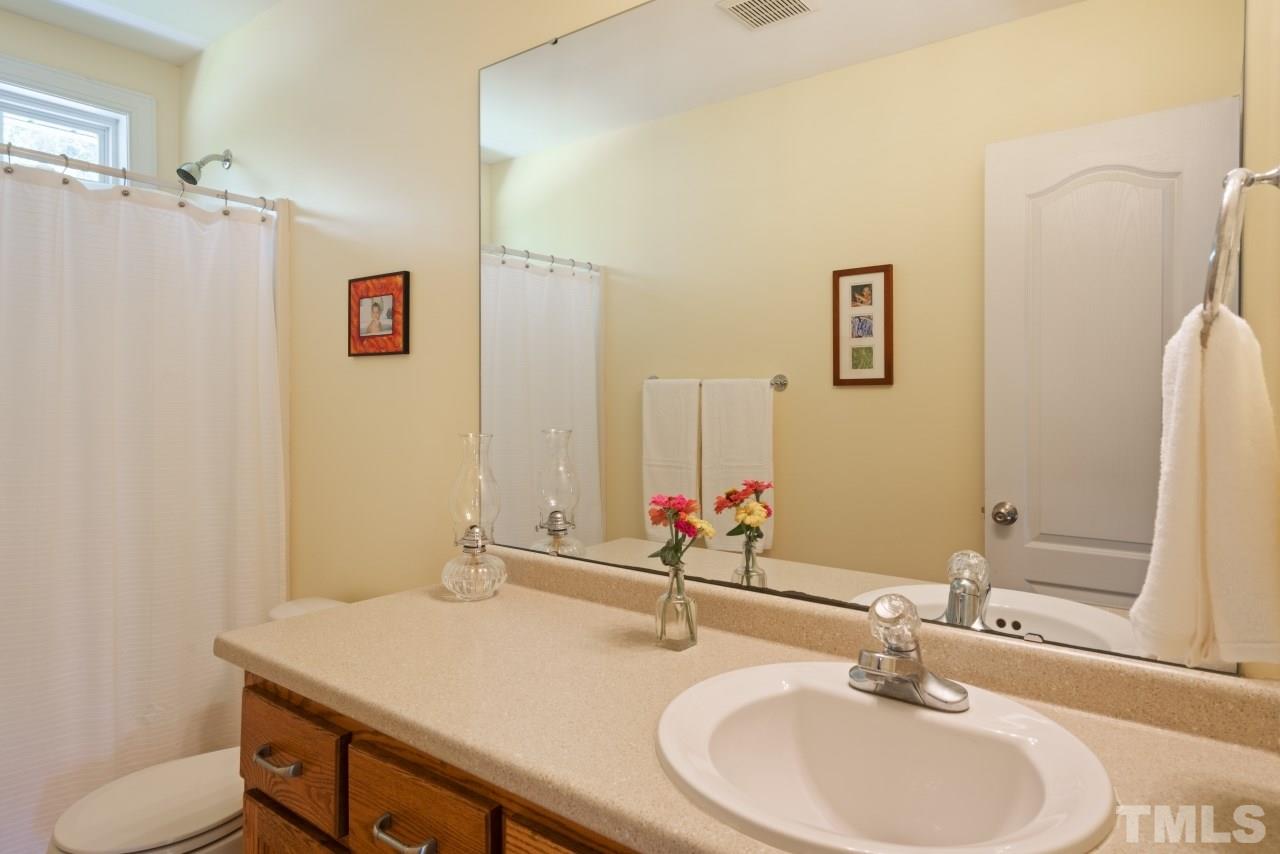 135 Cattle Farm Drive Raleigh, NC 27603 - Photo 22 of 30 a bathroom with a sink and a mirror
