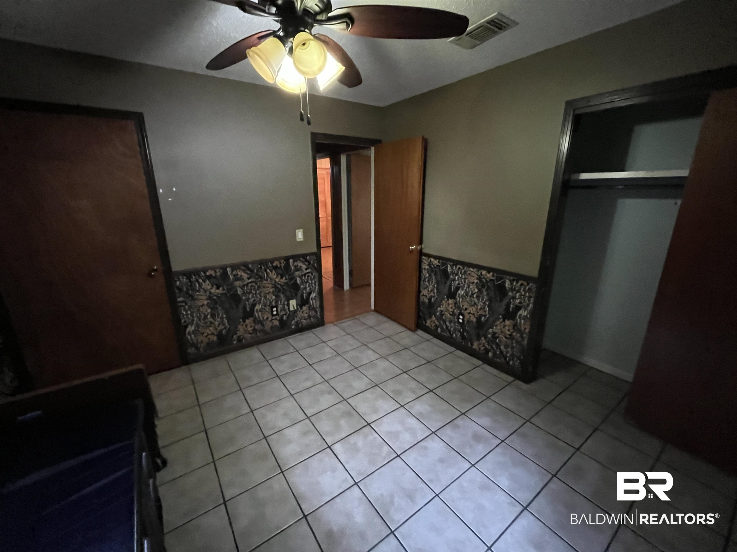 1905 Rockaway Creek Road Atmore, AL 36502 - Photo 17 of 23 Ceramic tile flooring, ceiling fan with integrated lighting, built-in closet with shelving, and wood-finish doors