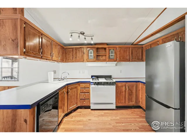 a kitchen with stainless steel appliances granite countertop a refrigerator a sink dishwasher a stove with wooden cabinets