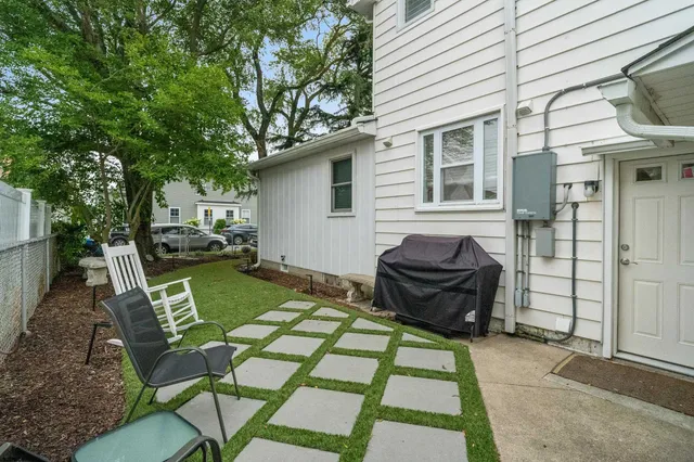 a view of a backyard with table and chairs and a barbeque