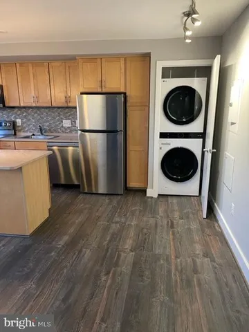 a view of a kitchen with wooden floor and stainless steel appliances
