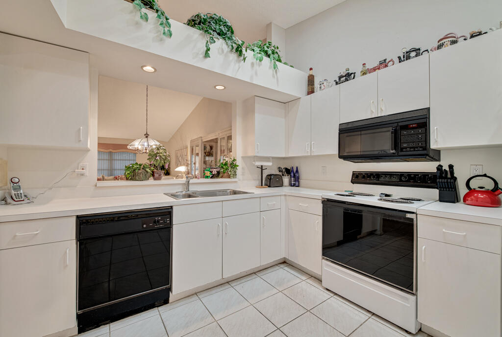 9976 Seacrest Circle, Unit A Boynton Beach, FL 33437 - Photo 11 of 48 a kitchen with a sink stove and microwave