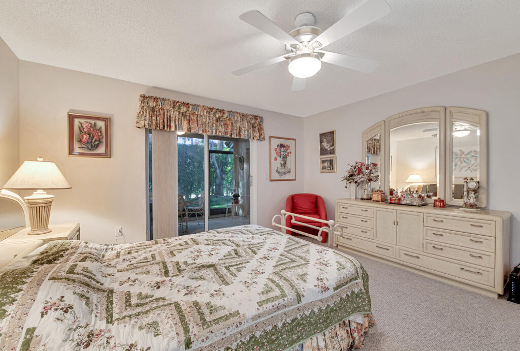 9976 Seacrest Circle, Unit A Boynton Beach, FL 33437 - Photo 17 of 48 a bedroom with a large bed and a chandelier